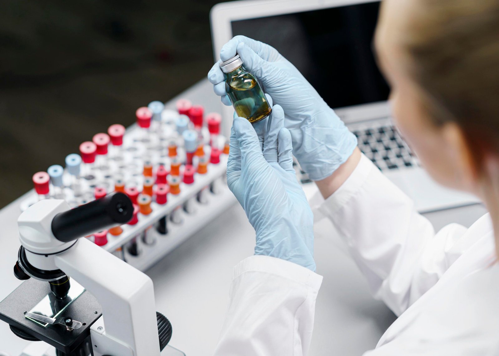 female researcher laboratory with test tubes vaccine bottle